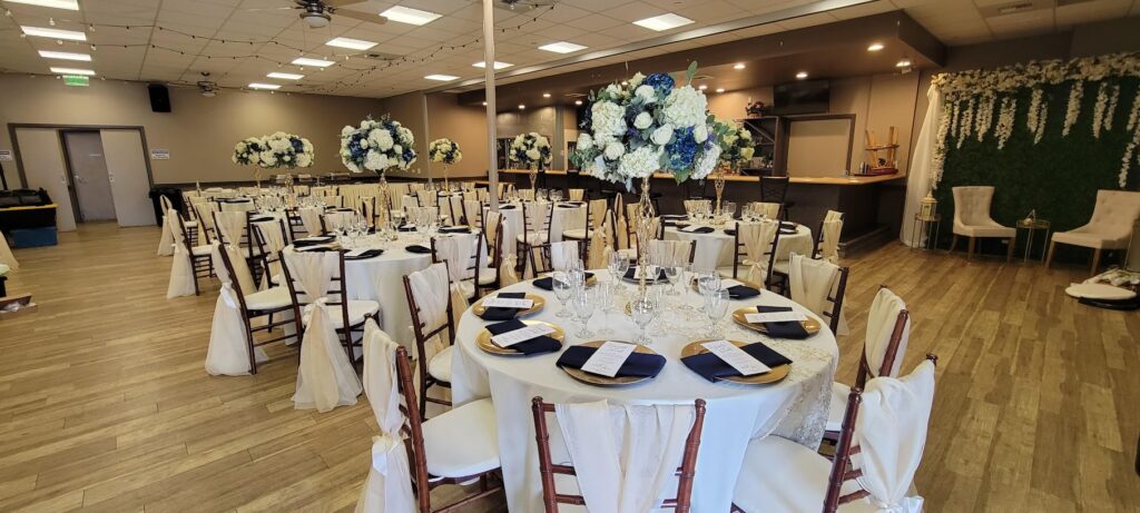 Banquet hall with decorated round tables and floral centerpieces at American Legion Post 106 in Redlands, CA.